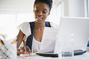 user of an invoice generator for small business smiling as she prepares one with ease