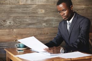 invoice to a company, man on suit in an office going through documents