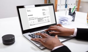 automating your invoicing process, man on PC creating an invoice