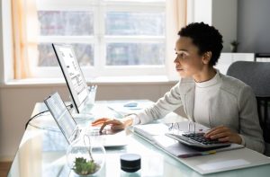 invoice in excel, woman looking at her Desktop and PC screens