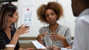 afro woman making gestures with her hands while explaining how to get investors for small business