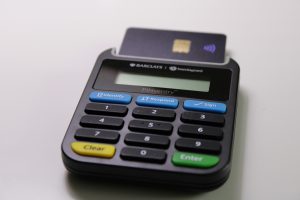 A small business owner accepts a mobile payment from a customer using a credit card reader.